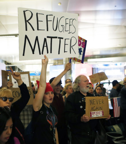 AP Photo Demonstrators hold up signs as protests against President Donald Trump's executive order banning travel from seven Muslim-majority countries continue at Los Angeles International Airport  on Sunday.